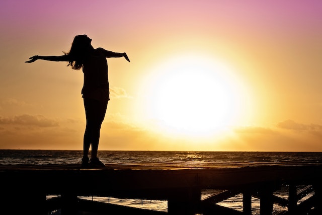 woman looking up with arms out in gratitude